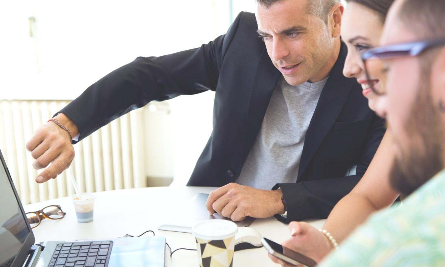 Person plant Budget am Schreibtisch mit Unterlagen und Taschenrechner